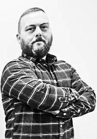 Man in a plaid shirt with arms crossed, representing the expertise and professionalism of The Generator Guys, a generator service company in Seaford, Delaware.